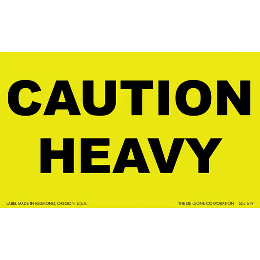 Yellow warning sign with black text reading ’CAUTION HEAVY’