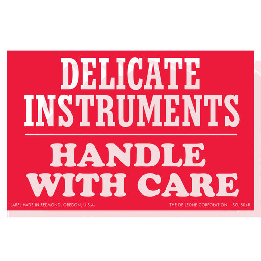 Red warning label with white text reading ’DELICATE INSTRUMENTS HANDLE WITH CARE’