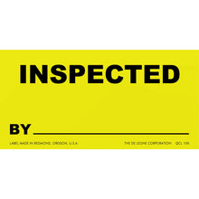 Yellow inspection label with black text reading ’INSPECTED BY’ and a blank line below.