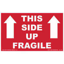 Red shipping label with white text reading ’THIS SIDE UP FRAGILE’ and upward-pointing arrows.