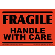 Red warning label with black text reading ’FRAGILE HANDLE WITH CARE’