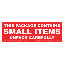 Red warning label with white text stating ’THIS PACKAGE CONTAINS SMALL ITEMS UNPACK CAREFULLY’
