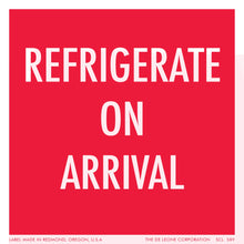 Red warning label with white text reading ’REFRIGERATE ON ARRIVAL’