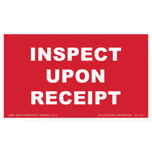 Red label with white text reading ’INSPECT UPON RECEIPT’
