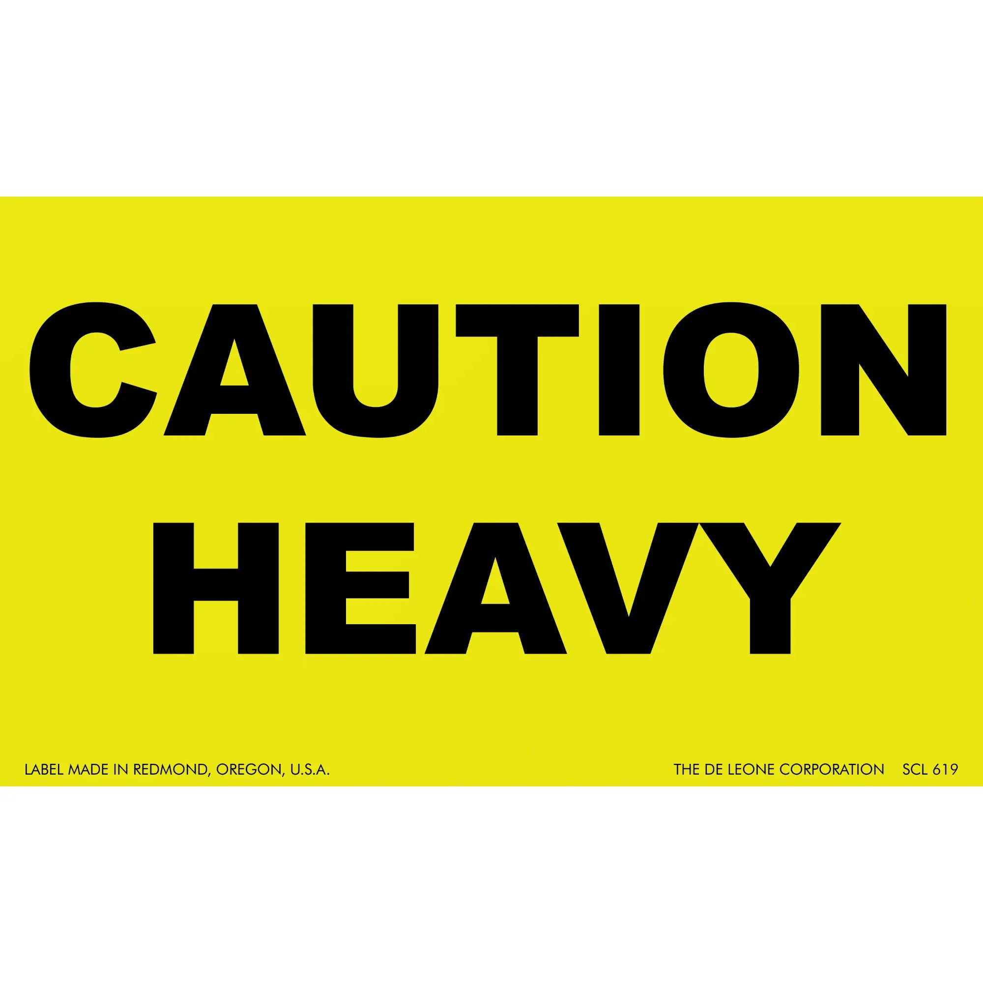 Yellow warning sign with black text reading ’CAUTION HEAVY’