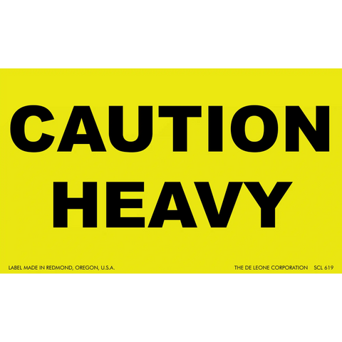 Yellow warning sign with black text reading ’CAUTION HEAVY’