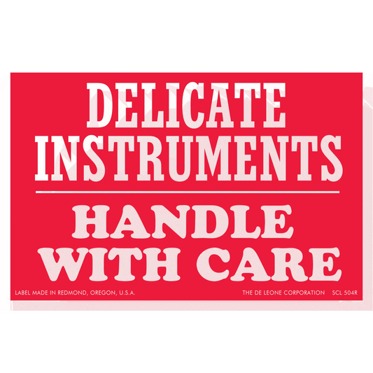 Red warning label with white text reading ’DELICATE INSTRUMENTS HANDLE WITH CARE’