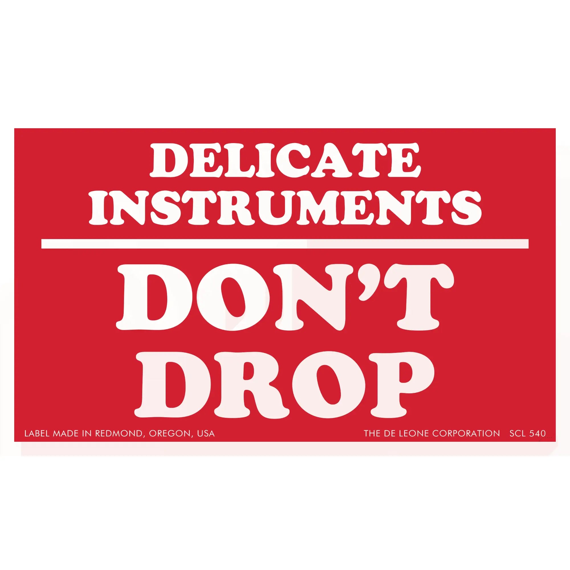 Red warning label with white text reading ’DELICATE INSTRUMENTS DON’T DROP’