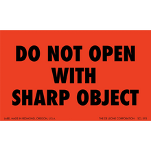 Red warning label with black text reading ’DO NOT OPEN WITH SHARP OBJECT’