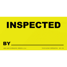 Yellow inspection label with black text reading ’INSPECTED BY’ and a blank line below.