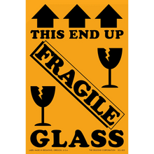 Warning label for fragile glass with black text and broken wine glass symbols on an orange background.