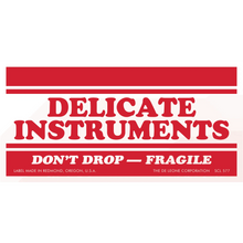 Red and white warning label for delicate instruments marked as fragile.