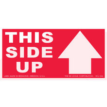 Red shipping label with white text reading ’THIS SIDE UP’ and an upward-pointing arrow.