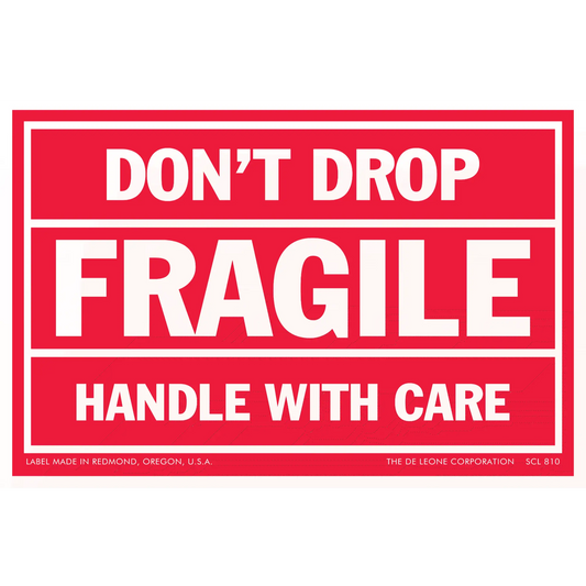 Red warning label with white text reading ’DON’T DROP FRAGILE HANDLE WITH CARE’