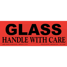 Red warning label with black text reading ’GLASS HANDLE WITH CARE’