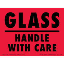 Red warning label with black text reading ’GLASS - HANDLE WITH CARE’