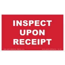 Red label with white text reading ’INSPECT UPON RECEIPT’