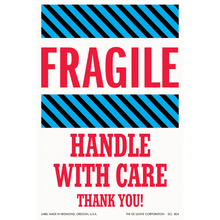 Warning label with ’FRAGILE - HANDLE WITH CARE’ text and diagonal striped borders.